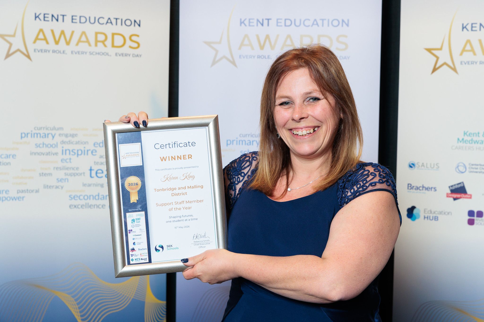 Karen King holds up her Kent Education Award certificate