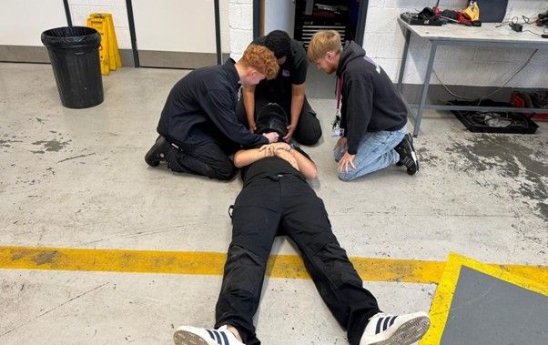Students providing first aid to dummy