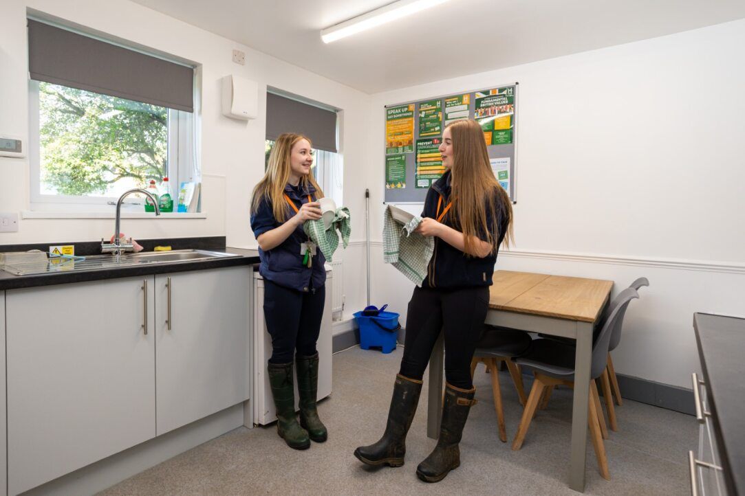 two students washing up in kitchen