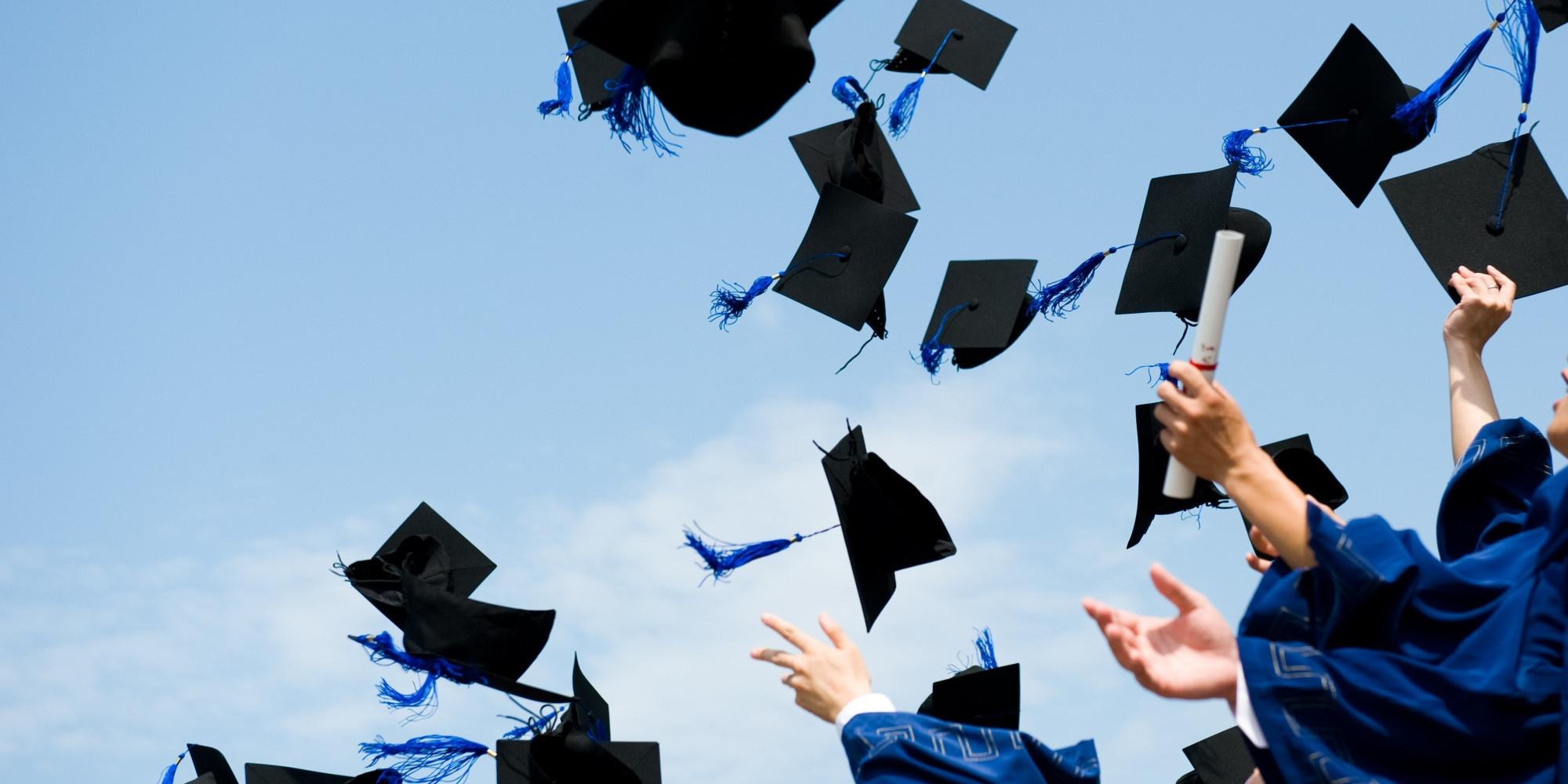 Students throwing graduation caps in the air. 