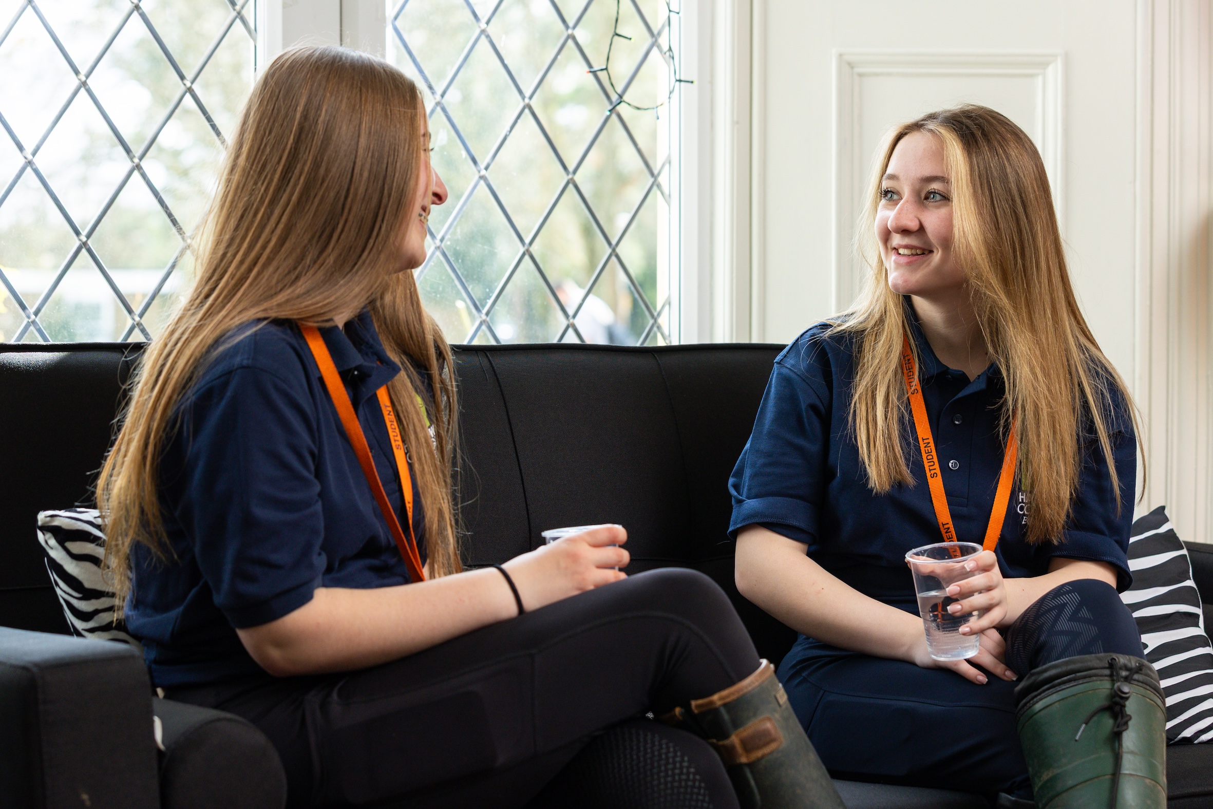 Two students sat on sofa talking