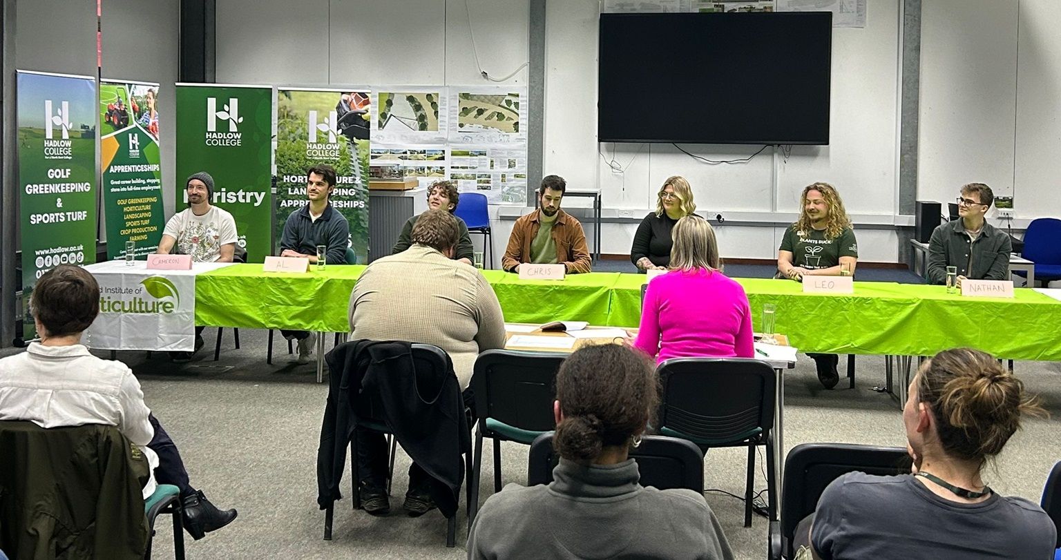 Adjudication panel at desks with crowd in front